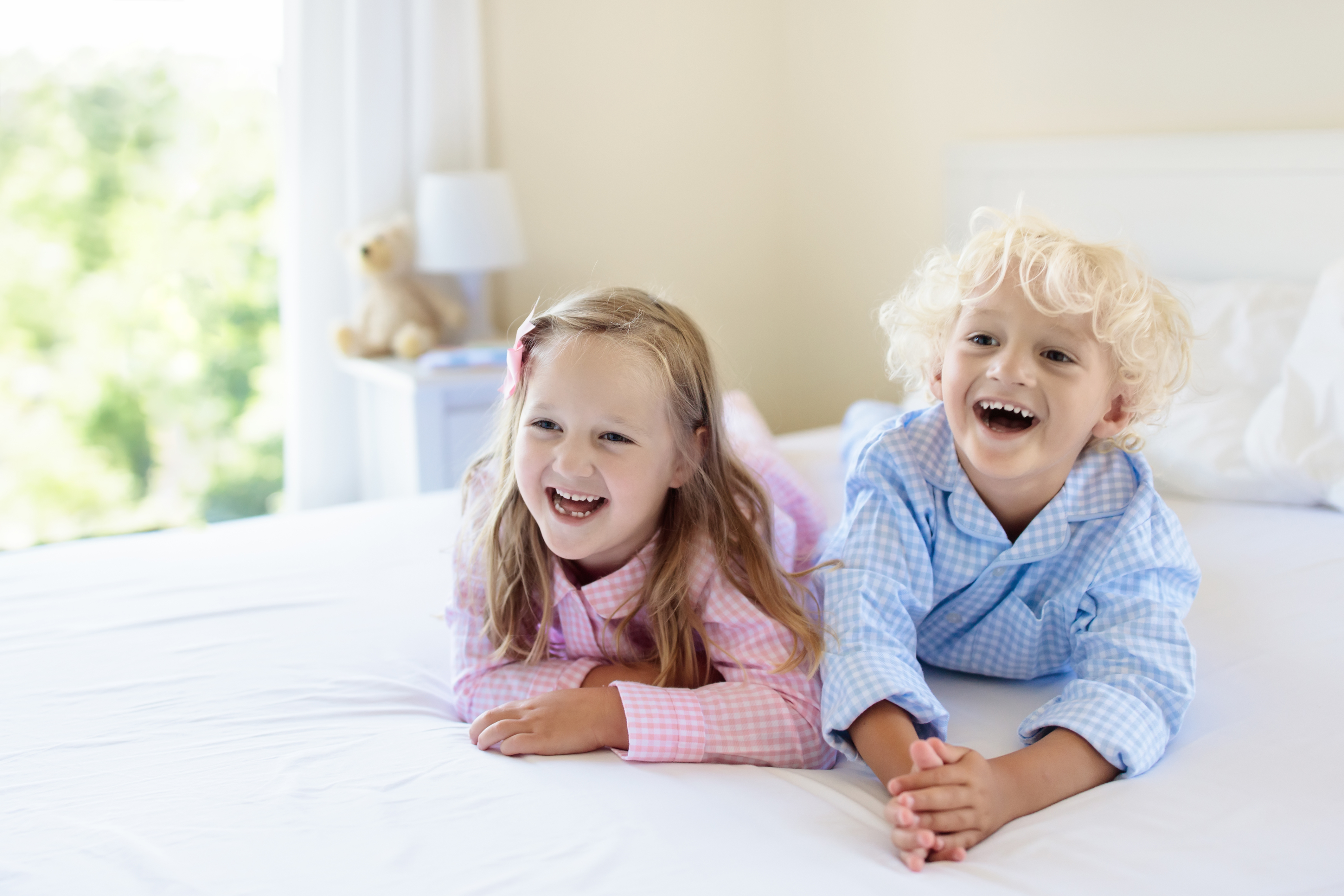 two children laughing on bed